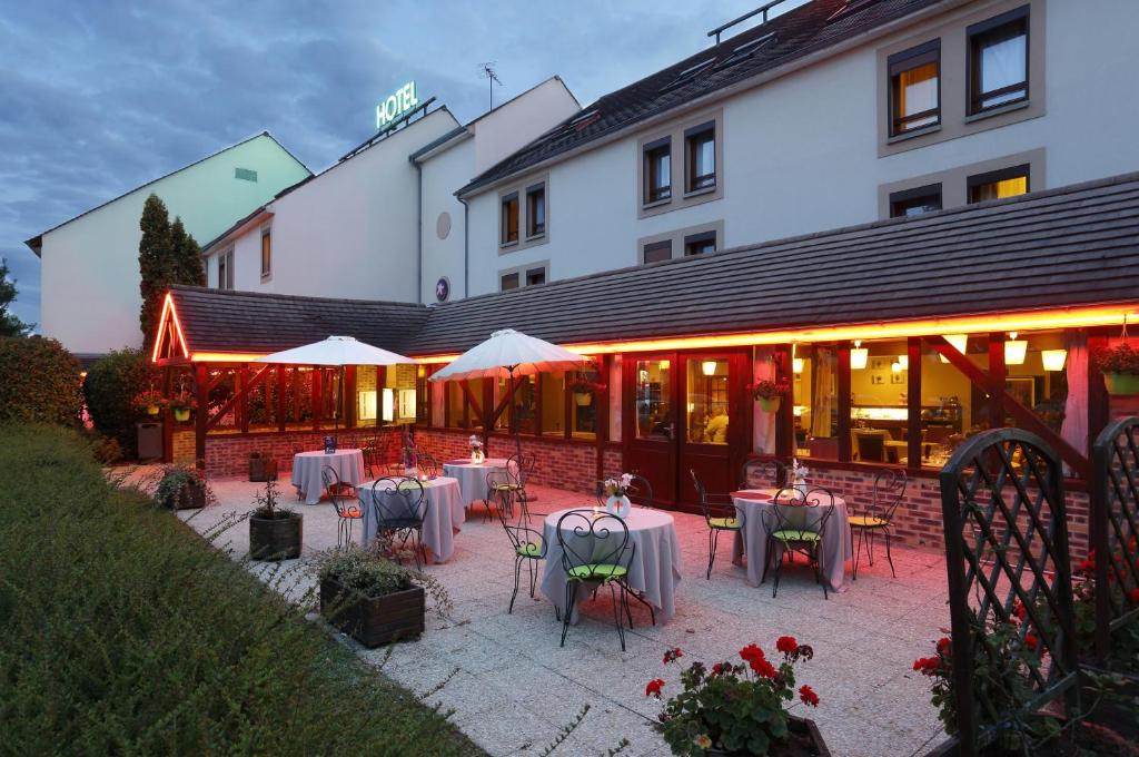 un restaurant avec des tables et des chaises en face d'un bâtiment dans l'établissement FastHôtel Blois, à Blois