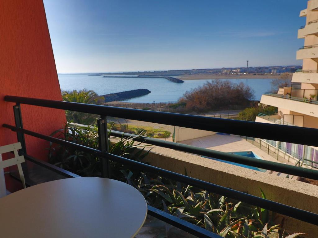 d'un balcon avec une table et une vue sur l'eau. dans l'établissement Appartement climatisé avec loggia, 2 pièces, 4 pers, 2 Clés vacances à Sète - FR-1-472A-248, à Sète