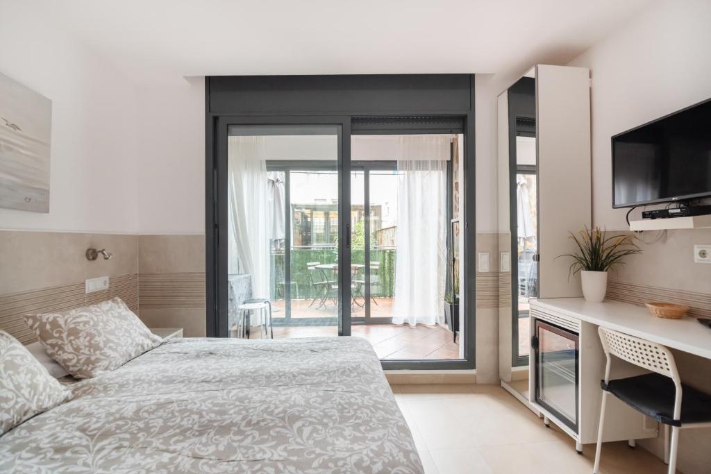 a bedroom with a bed and a desk with a television at Hostal House in Barcelona