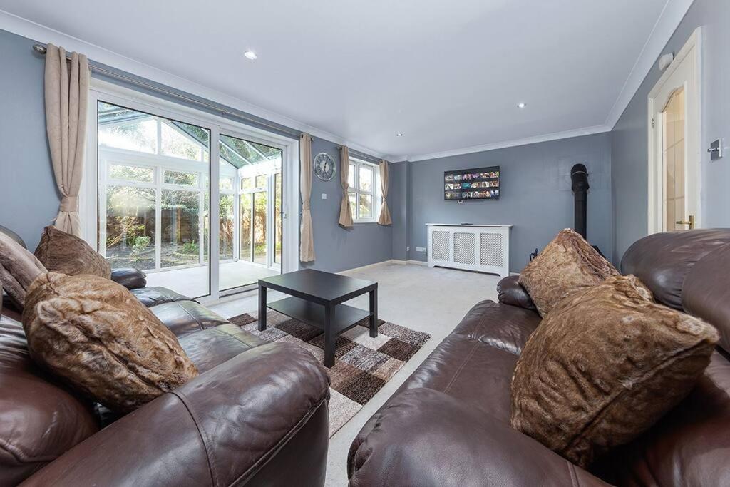 a living room with a leather couch and a table at Flourish Apartments - Footbury House - Orpington in Orpington