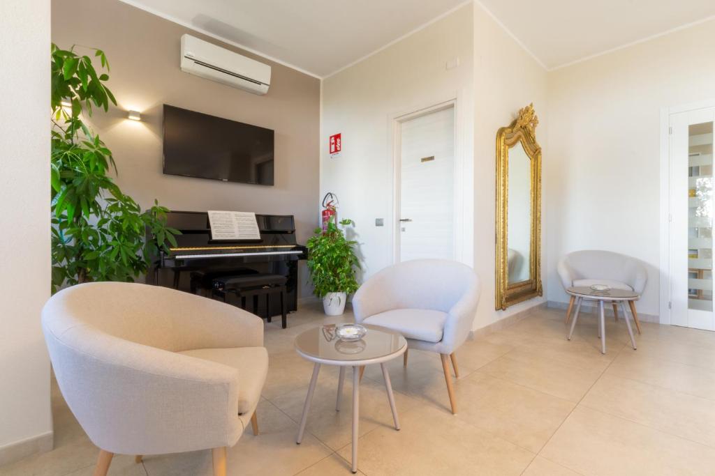 a living room with a piano and chairs and a table at New Ca'Mea in Villasimius