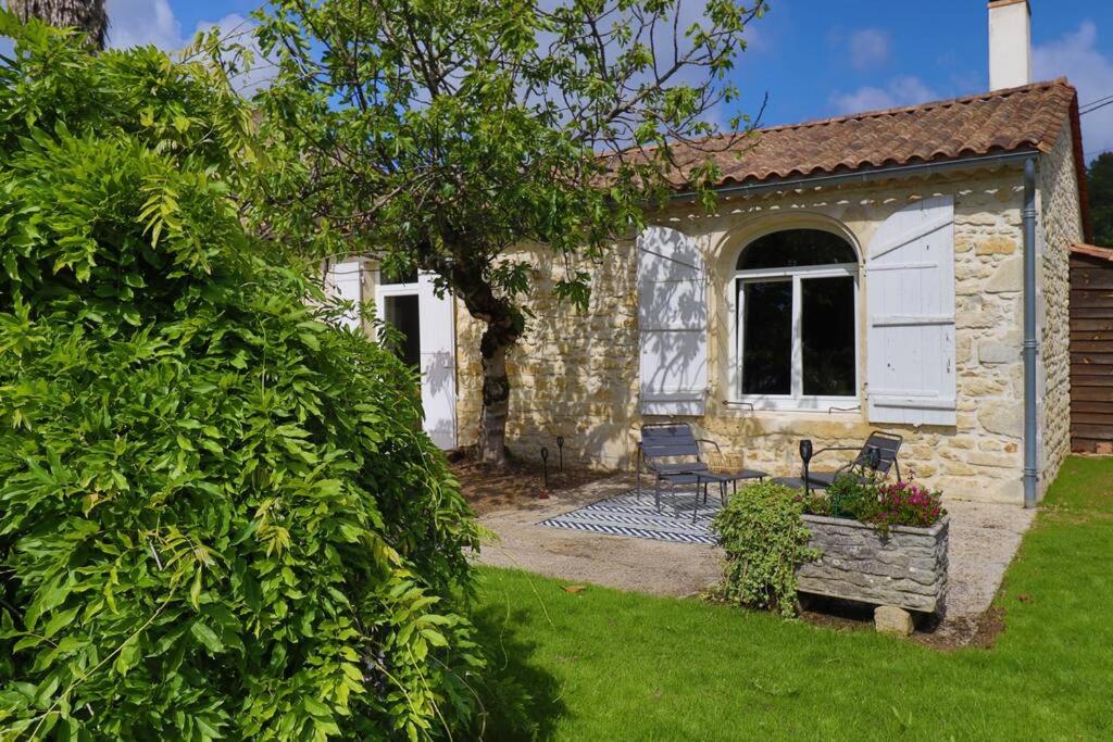 un cottage in pietra con panchina nel cortile di L’océan 20 a Queyrac