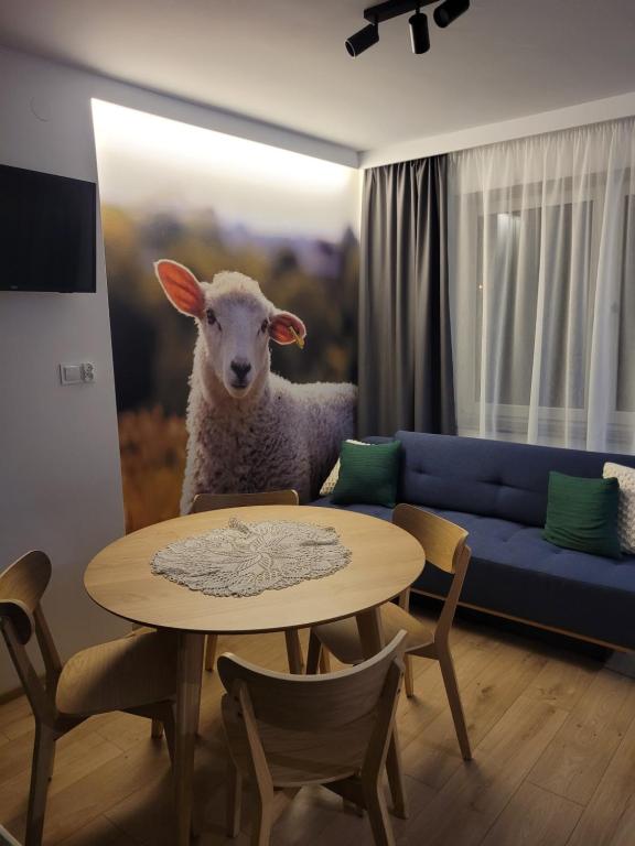 a sheep standing in a living room with a table at Daglezja in Przyborów