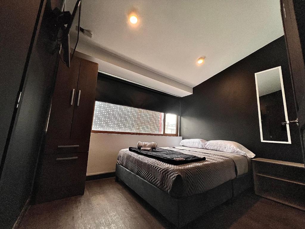 Un dormitorio con una cama grande y una ventana en ORANGE CITY HOTEL, en Bogotá