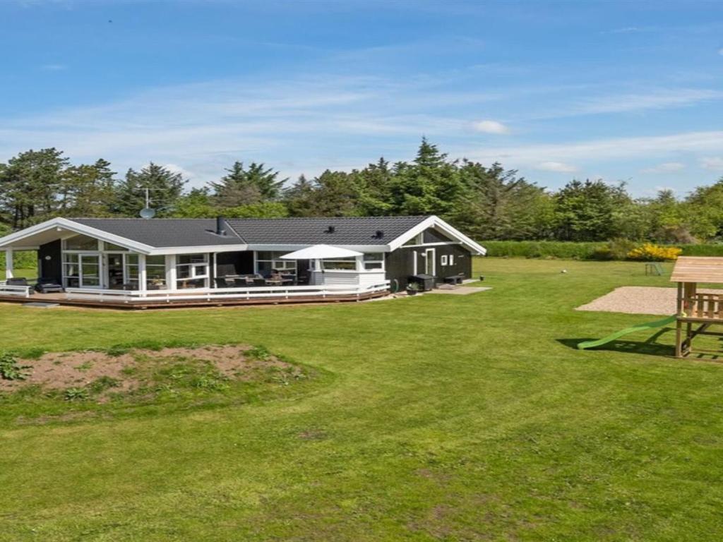 a house with a large yard with a picnic table at Holiday Home Sviðandi - 1-5km from the sea in Western Jutland by Interhome in Ringkøbing