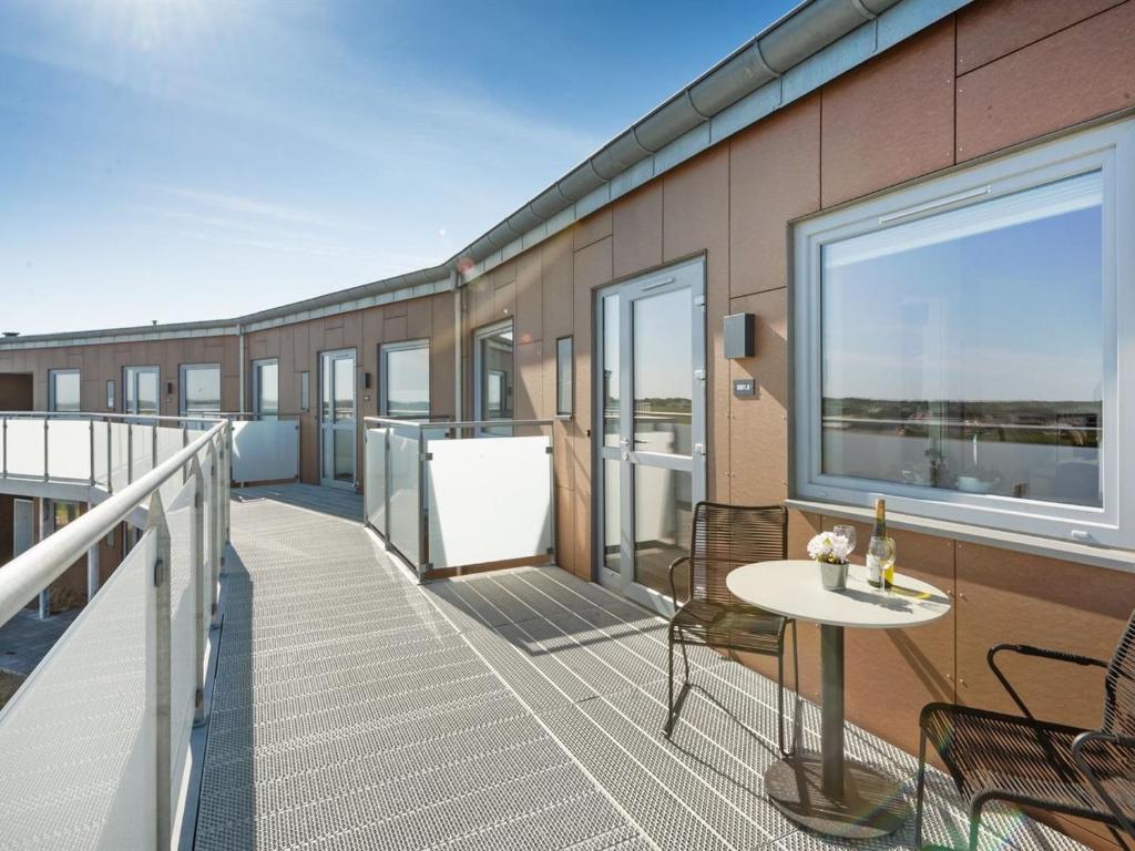 a balcony with a table and chairs on a building at Apartment Aiana - 250m from the sea by Interhome in Ringkøbing