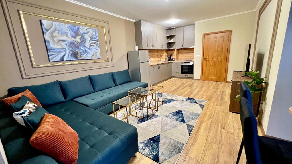 een woonkamer met een blauwe bank en een keuken bij Gondola Apartments Lux in Bansko