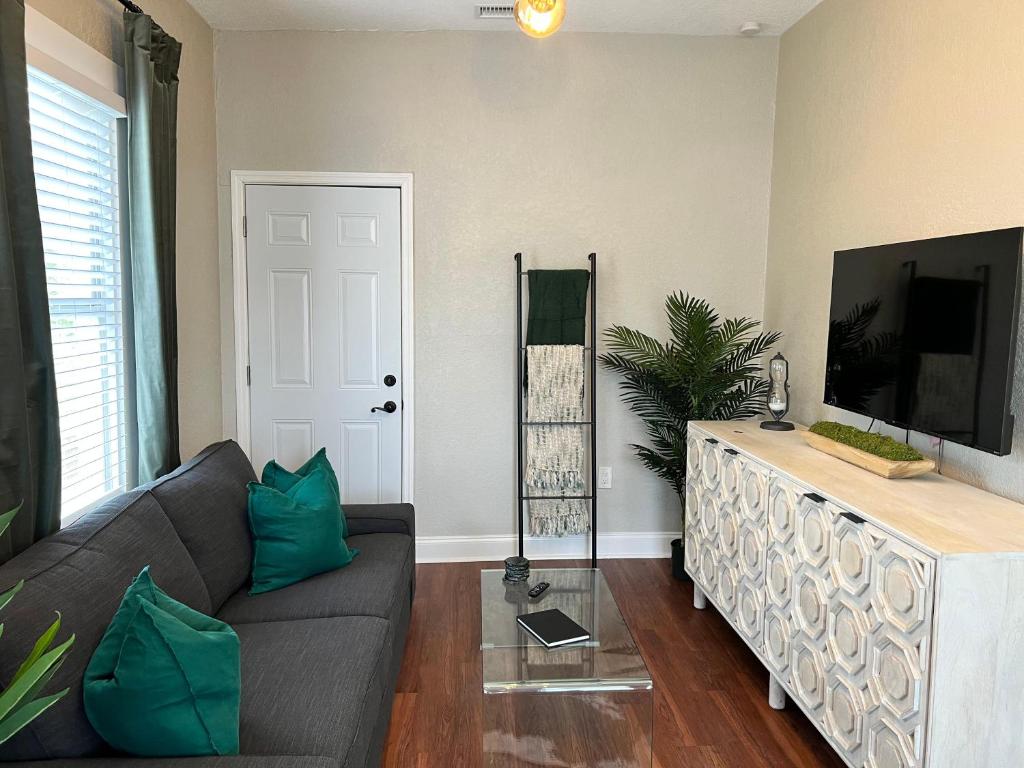 sala de estar con sofá y TV de pantalla plana en Updated Condo in Heart of Tampa 2, en Tampa