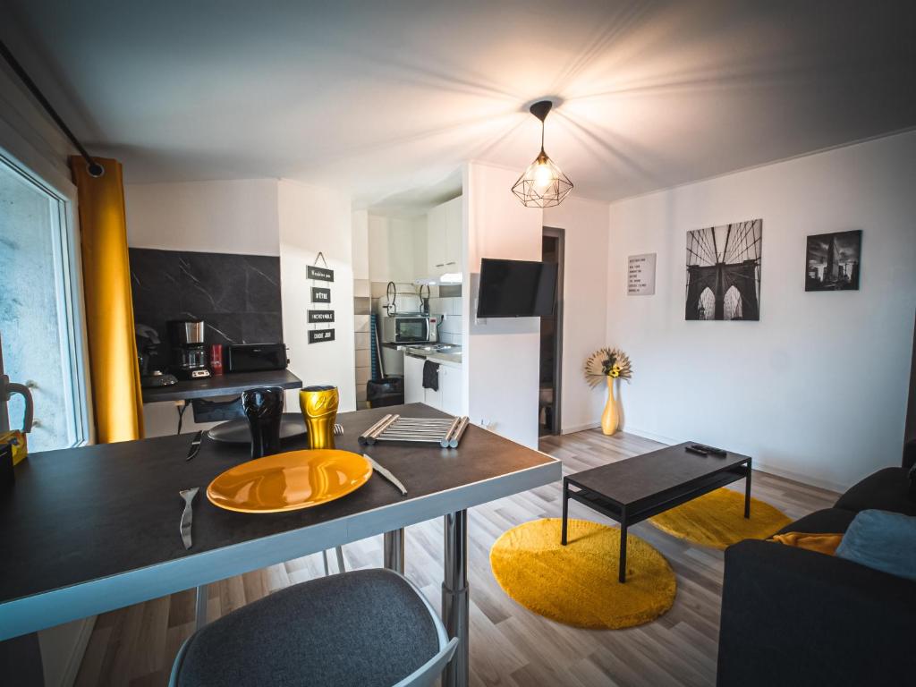 a kitchen and living room with a table and chairs at Le P'tit Jeanne d'Arc Logements Insolites in Nancy