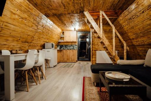uma sala de estar com um sofá e uma mesa em CabanaAframe intreaga proprietate em Curtea de Argeş