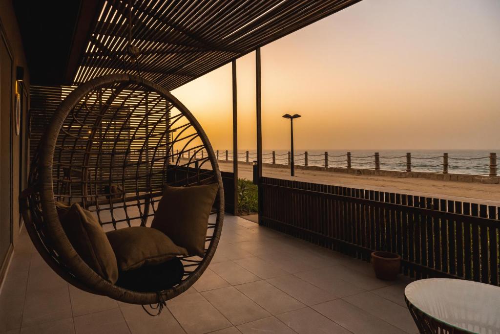 a hanging chair on a balcony overlooking the beach at Tulum Beach Resort Dakhla in Dakhla