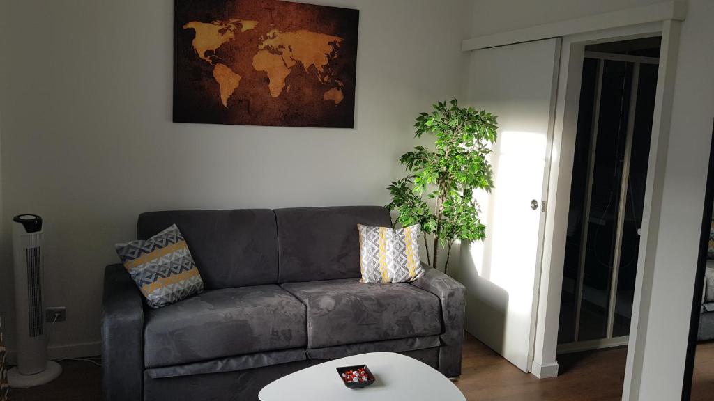 ein Wohnzimmer mit einem Sofa und einem Tisch in der Unterkunft Suite Deluxe, voyages d'affaires. in Saint-Nazaire