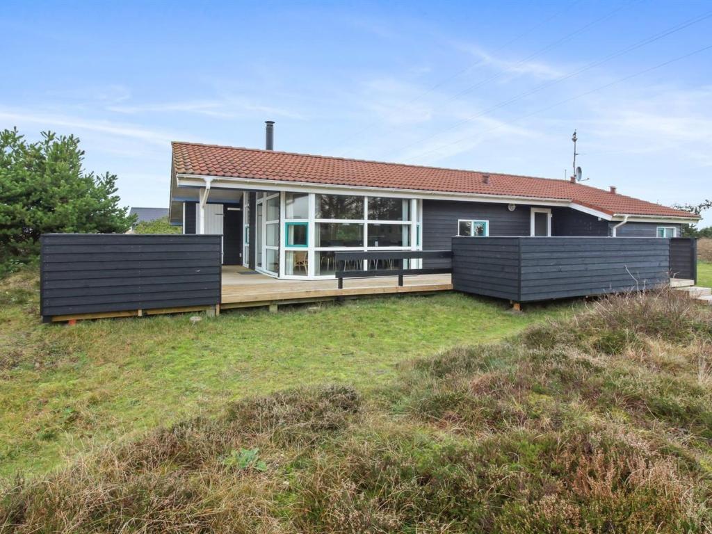 a house on top of a grassy hill at Holiday Home Andrie - 800m from the sea in Western Jutland by Interhome in Hvide Sande