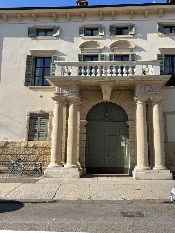 budynek z zielonymi drzwiami i balkonem w obiekcie Antiche Colonne w Weronie