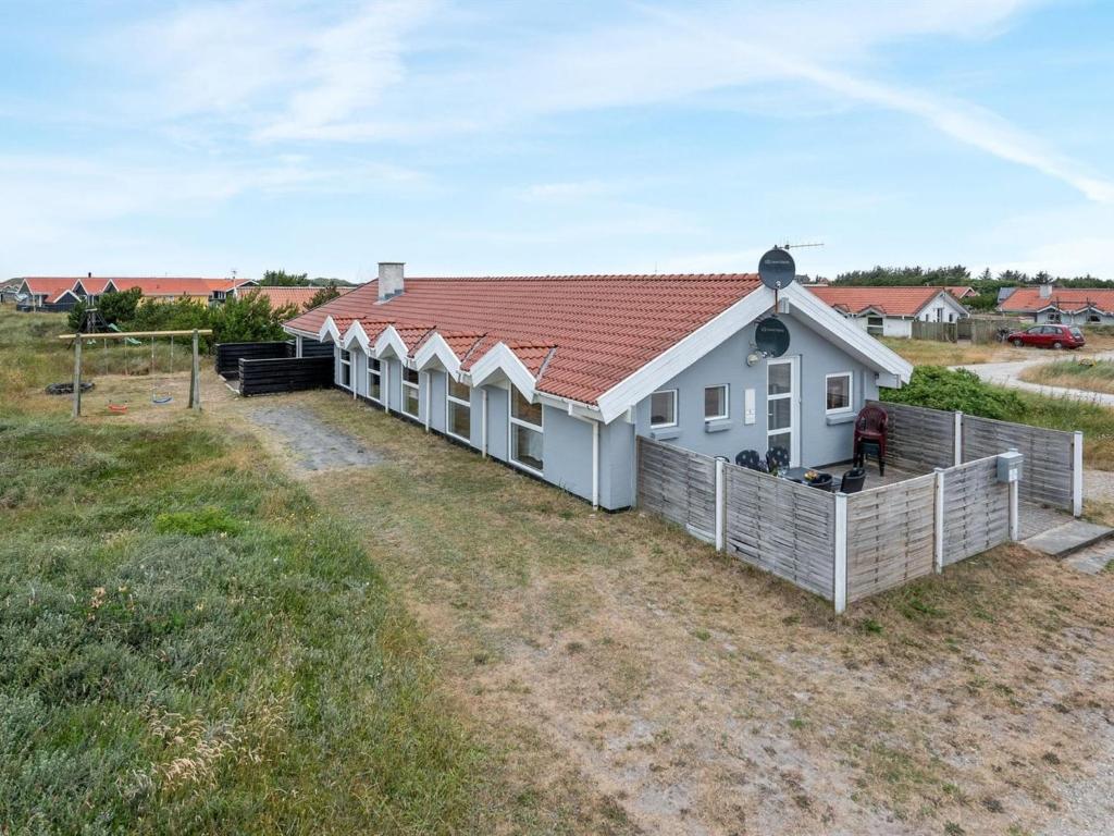 uma casa branca com um telhado vermelho num campo em Holiday Home Luzy - 600m from the sea in NW Jutland by Interhome em Torsted
