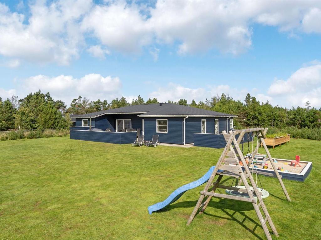 einen Spielplatz vor einem blauen Haus in der Unterkunft Holiday Home Ingwio - 1-5km from the sea in NW Jutland by Interhome in Torsted