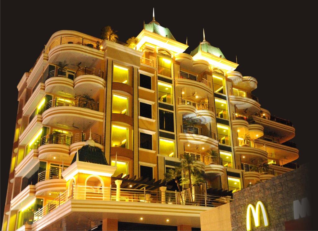 a large building with a mcdonalds at night at Fields Plaza Hotel by ABC in Angeles