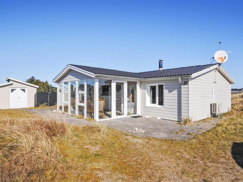 a white house on the side of a field at Holiday Home Avelin - 800m from the sea in NW Jutland by Interhome in Torsted
