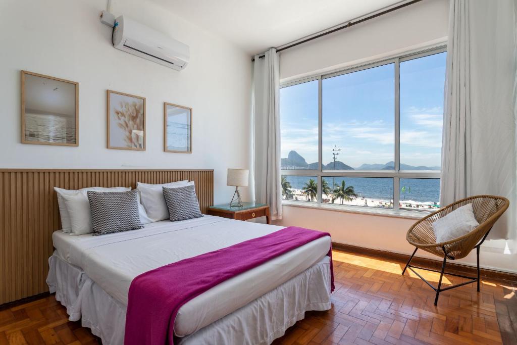 a bedroom with a bed and a large window at Sofisticado em Copacabana - Vista para praia - A403 Z3 in Rio de Janeiro