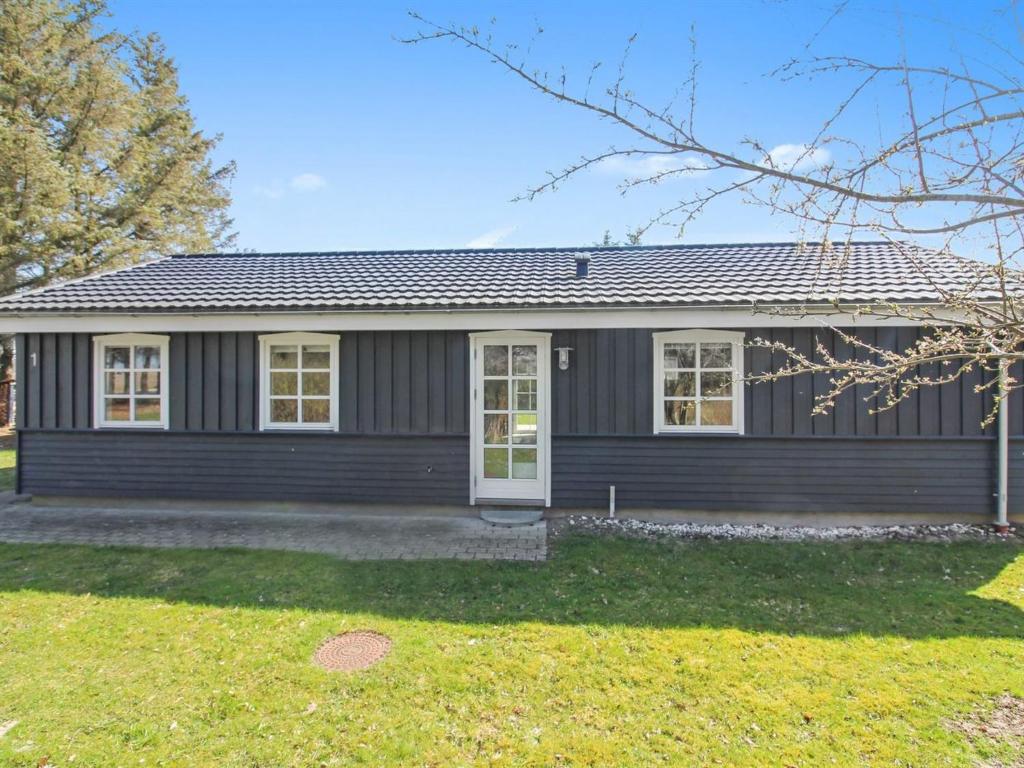 Ein Haus mit einem schwarzen Haus in der Unterkunft Holiday Home Nanja - 759m from the sea in NW Jutland by Interhome in Løkken
