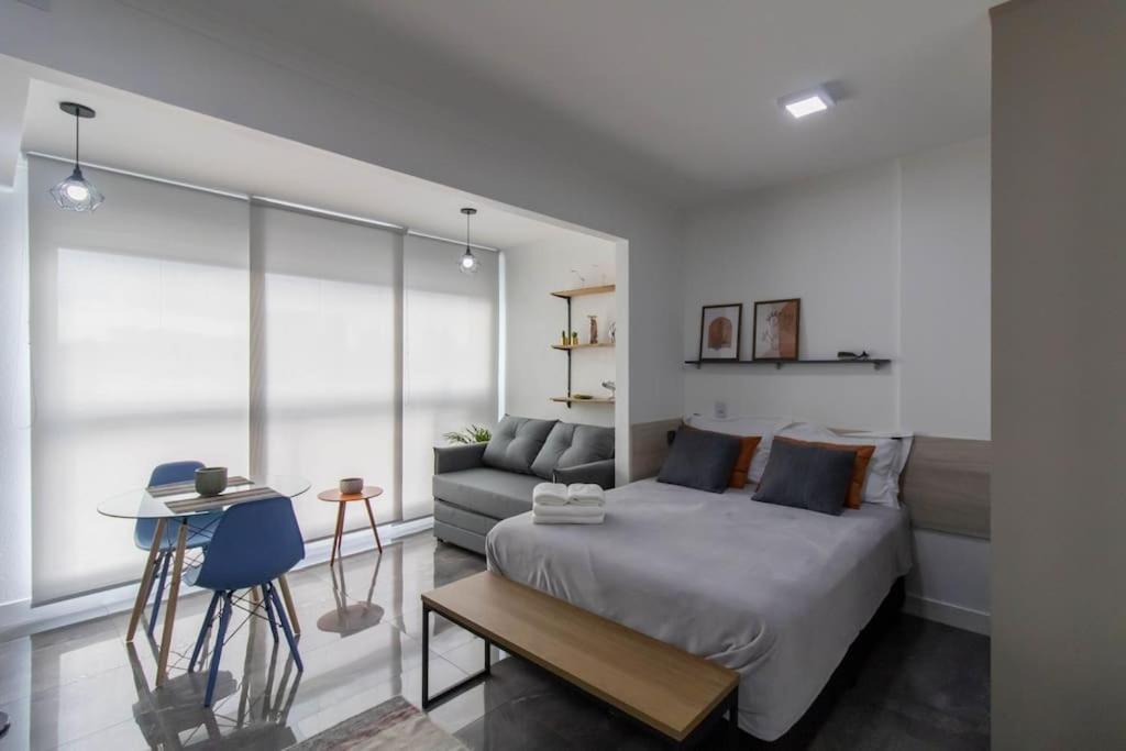 um quarto com uma cama e um sofá em Contemporary Studio - GRU em Guarulhos