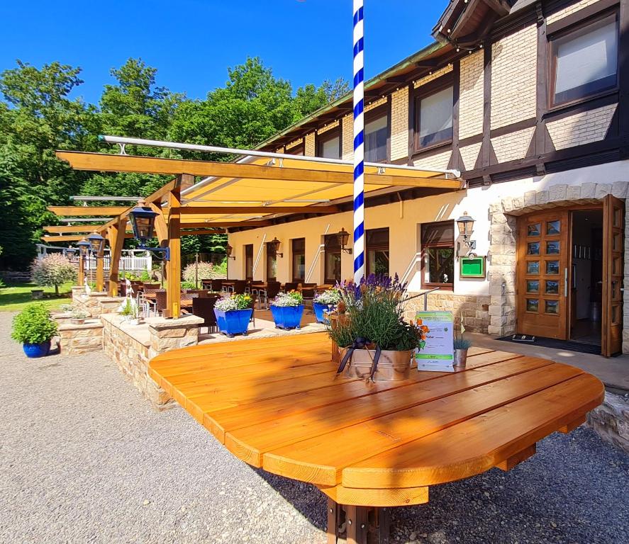 una mesa de madera frente a un edificio en Hotel Waldquelle - Baumhaushotel Aerzen, en Aerzen