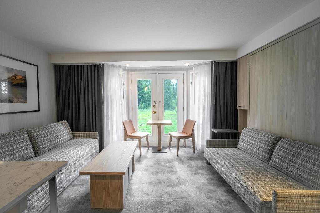 a living room with couches and a table and chairs at Lake Louise Inn in Lake Louise