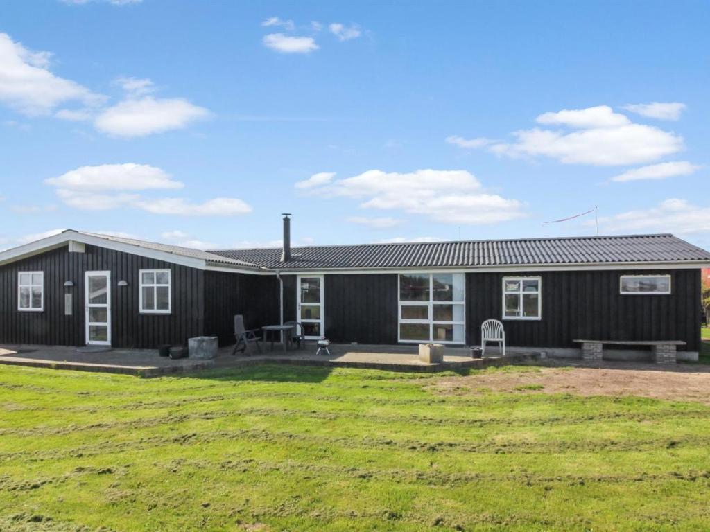 a black house with a yard in front of it at Holiday Home Fabio - 450m from the sea in NW Jutland by Interhome in Løkken