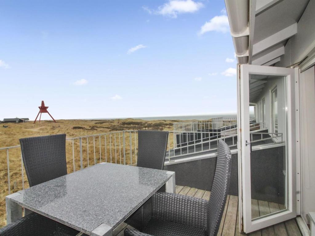 een tafel en stoelen op een balkon met uitzicht op het strand bij Apartment Meglena - 50m from the sea in NW Jutland by Interhome in Løkken
