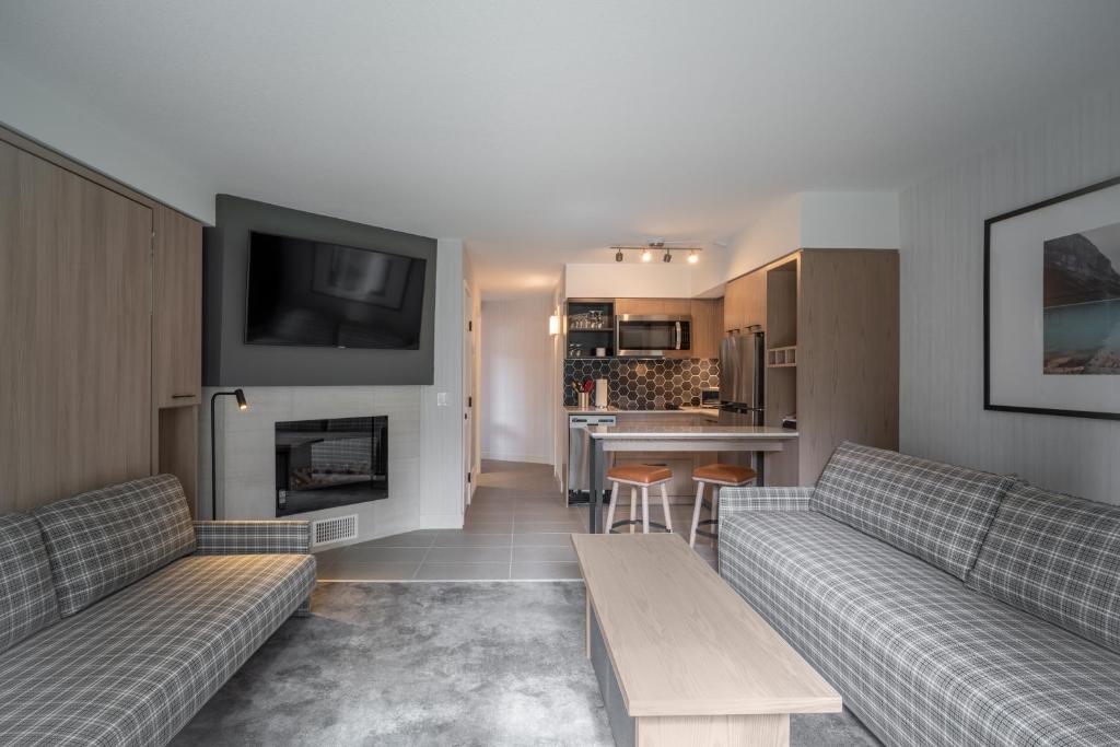 a living room with two couches and a fireplace at Lake Louise Inn in Lake Louise