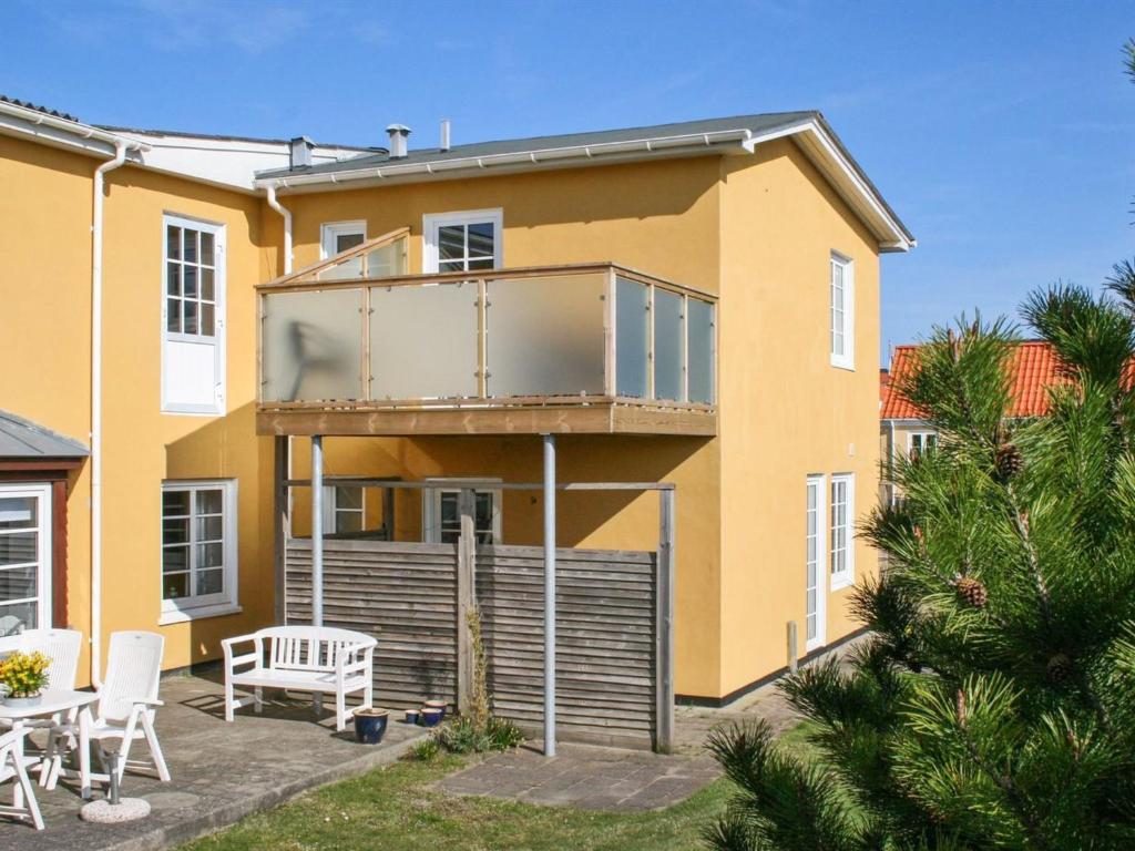 Cette maison dispose d'un balcon avec une table et des chaises. dans l'établissement Apartment Jördis - 150m from the sea in NW Jutland by Interhome, à Løkken