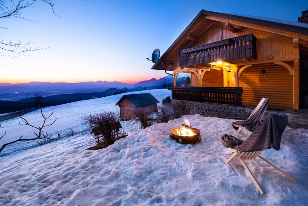 eine Feuerstelle im Schnee vor einer Hütte in der Unterkunft Lunela estate with sauna in Cerklje na Gorenjskem