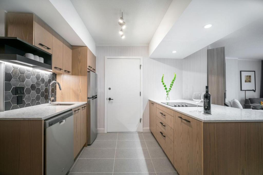 a kitchen with wooden cabinets and a white door at Lake Louise Inn in Lake Louise