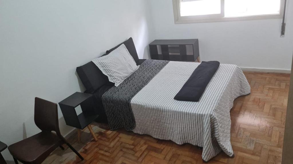 a bedroom with a bed with a black and white blanket at HOSTEL SANTOS PRAIA in Santos