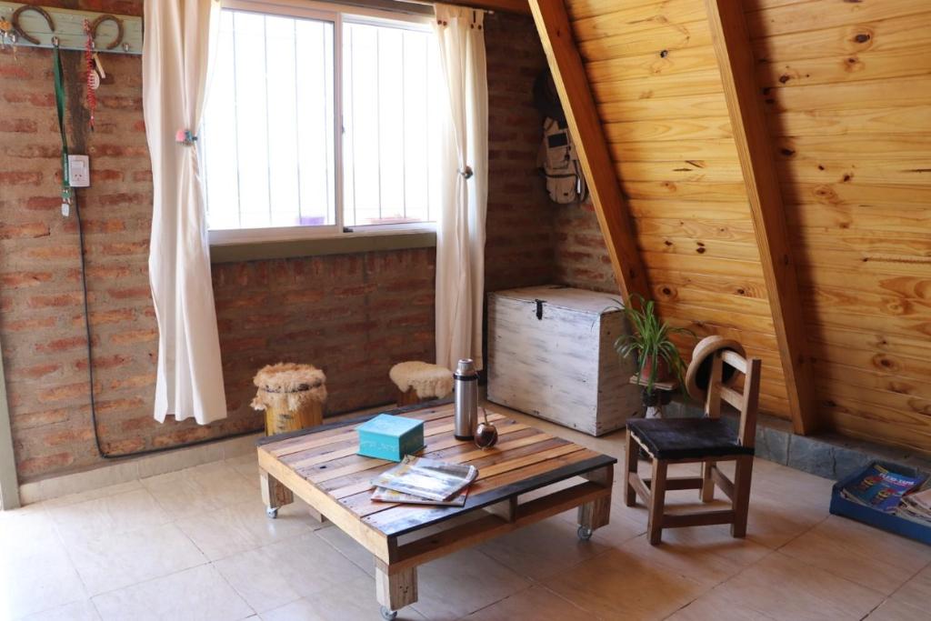 Arroyito cabaña agreste في Arroyito Challacó: غرفة معيشة مع طاولة خشبية ونافذة