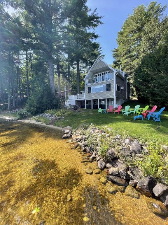 a house with colorful chairs on the lawn at TREMONT LIMIT 10 villa in Bridgton