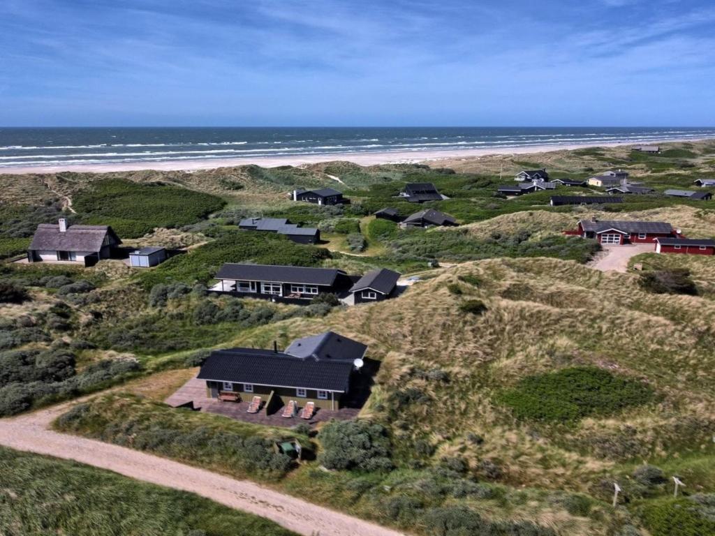 een luchtzicht op een huis op een heuvel naast het strand bij Holiday Home Arita - 250m from the sea in NW Jutland by Interhome in Saltum