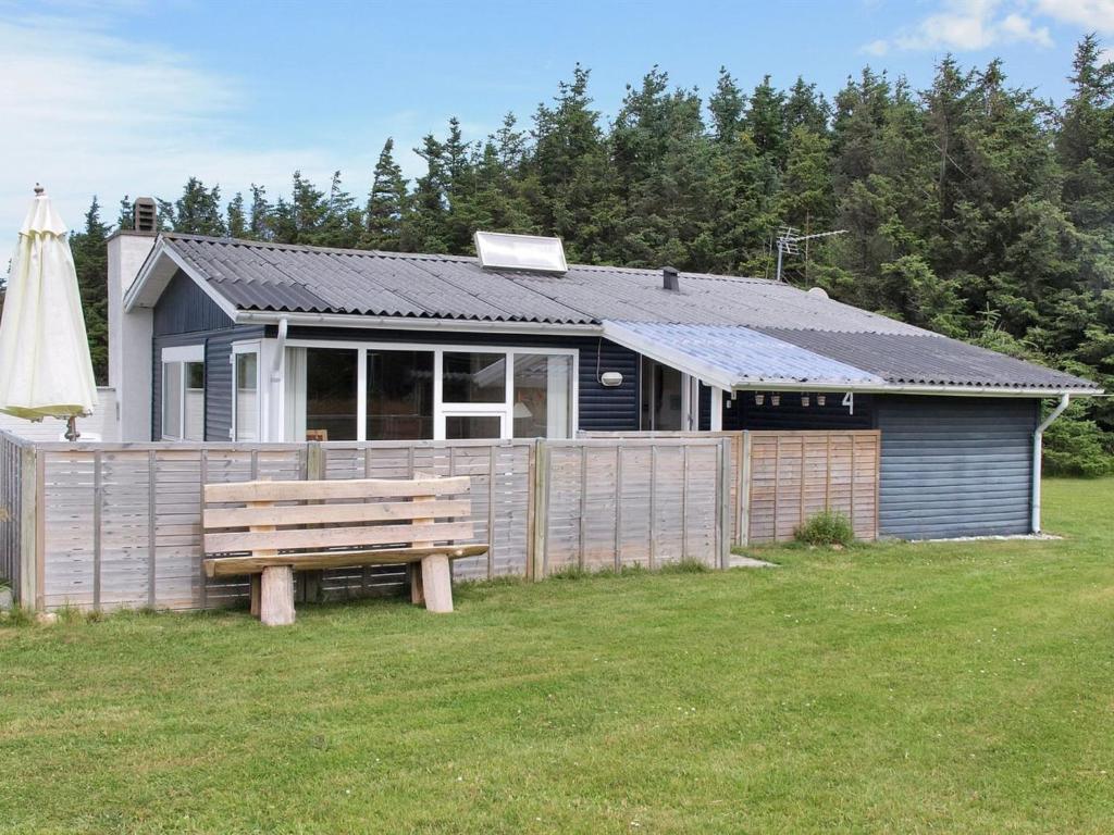 a house with a bench in front of it at Holiday Home Liisi - 500m from the sea in NW Jutland by Interhome in Hjørring