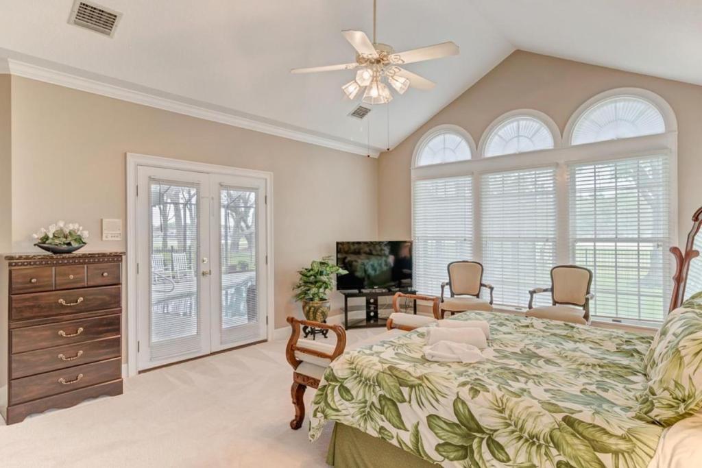 a bedroom with a bed and a ceiling fan at Club Views - Pool Home in Ponte Vedra Beach