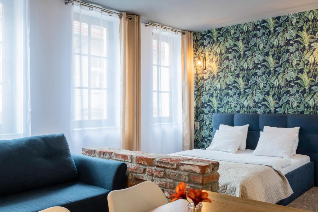 a bedroom with a bed and a couch and a wall at Staycity Apartments Sukiennice 6 in Wrocław