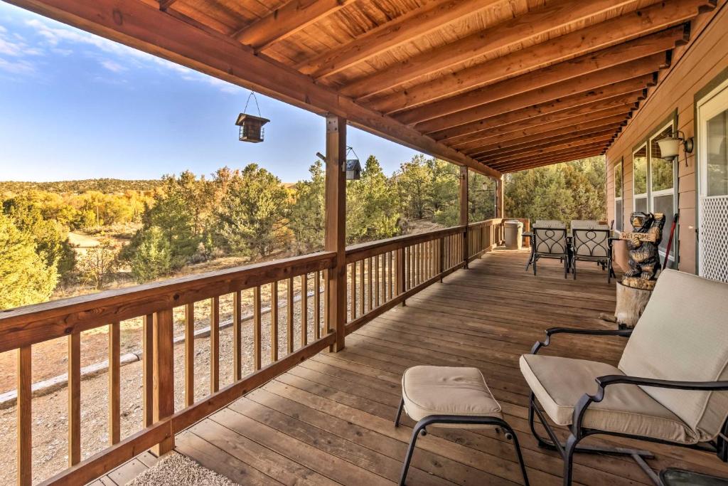 eine Terrasse mit Stühlen und Waldblick in der Unterkunft Cozy Ski Cabin with Deck Near Taos Ski Valley! in San Cristobal