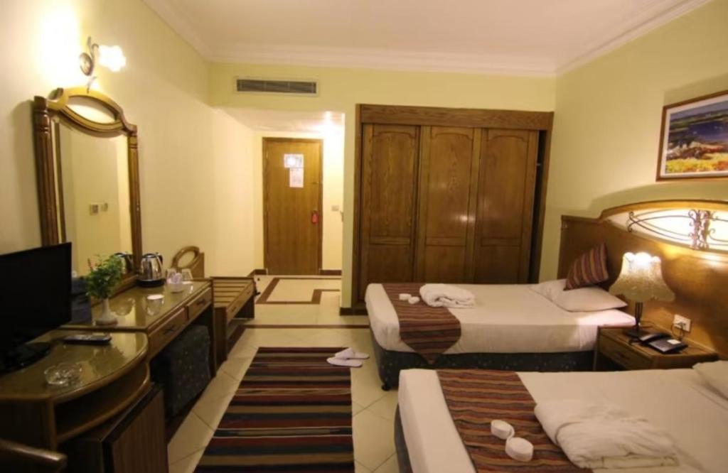 a hotel room with two beds and a bathroom at Reale savoia in Sharm El Sheikh