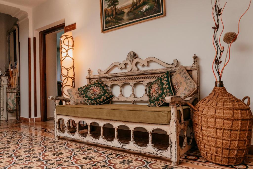 una cama antigua en una habitación con un jarrón en Casa Capricho del Destino, 