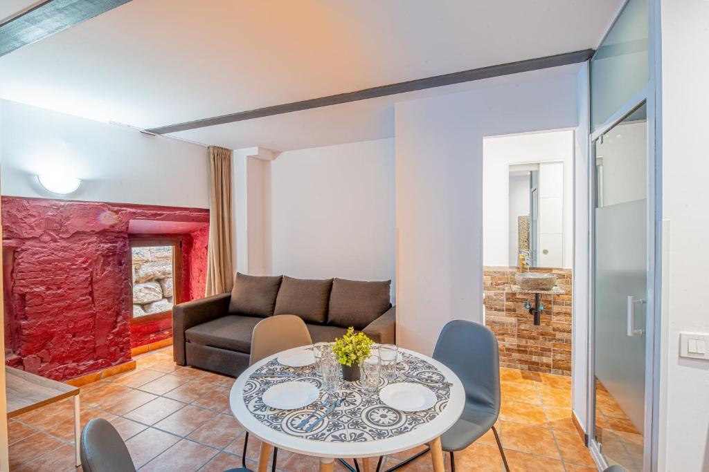 ein Wohnzimmer mit einem Tisch und einem Sofa in der Unterkunft Apartamento 1 en la muralla romana junto a la Catedral in Tarragona