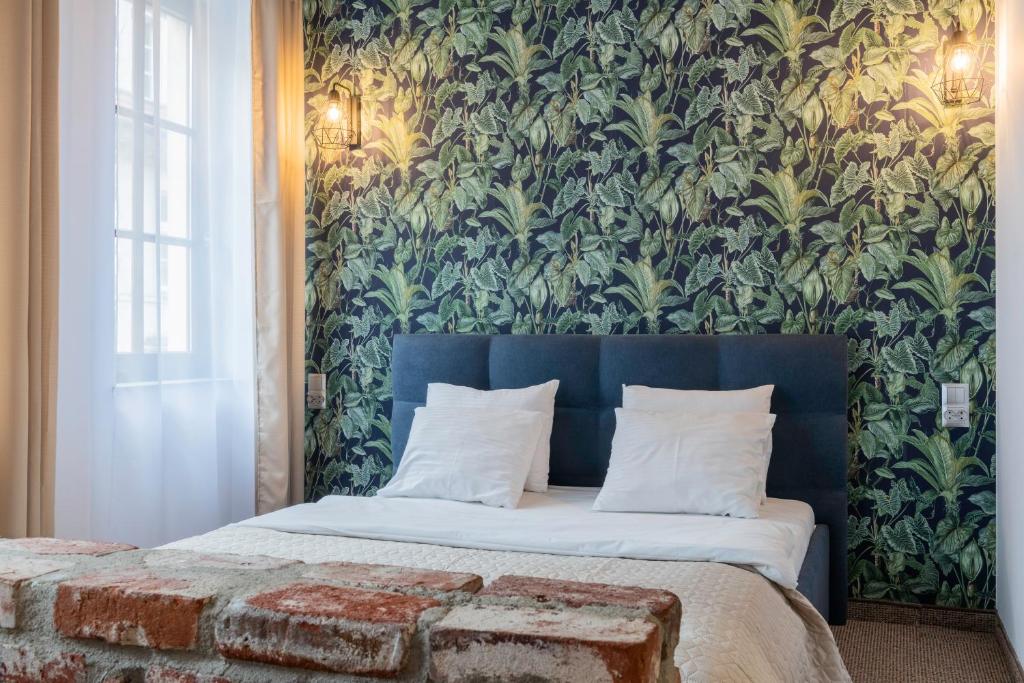 a bedroom with a bed with a floral wallpaper at Staycity Apartments Sukiennice 6 in Wrocław