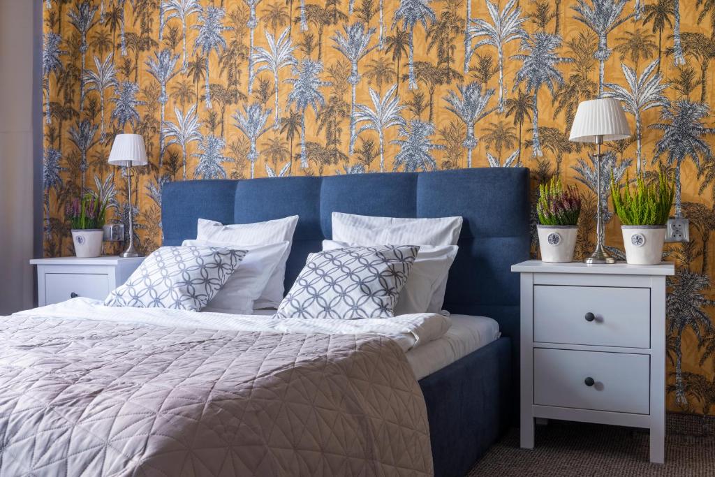 a bedroom with a blue bed with a blue and yellow wallpaper at Staycity Apartments Sukiennice 6 in Wrocław