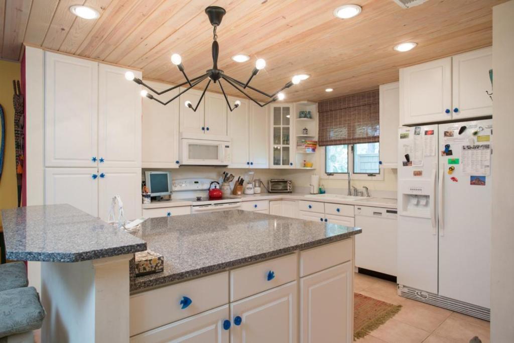 a kitchen with white cabinets and a wooden ceiling at Fisherman's Recess in Ponte Vedra Beach