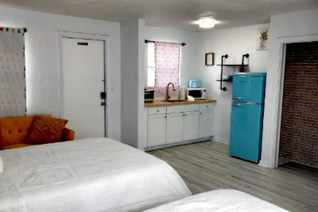 a room with a bed and a blue refrigerator at Pineapple Shores Inn Unit 1 in Daytona Beach