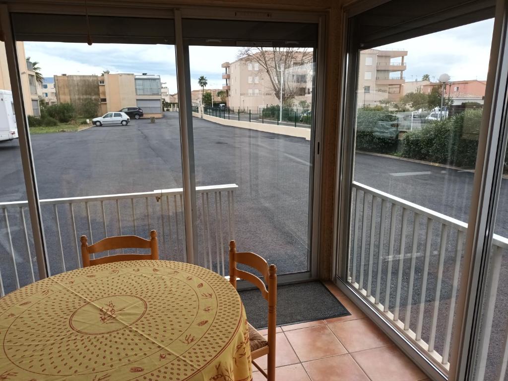 a table on a balcony with a view of a street at valras appartement T2 proche mer et port in Valras-Plage