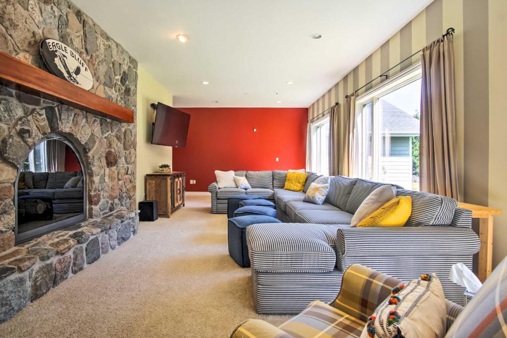 - un salon avec un canapé et une cheminée en pierre dans l'établissement Hot Tub and Sauna! 7-Acre Coastal Michigan Home, à Ludington